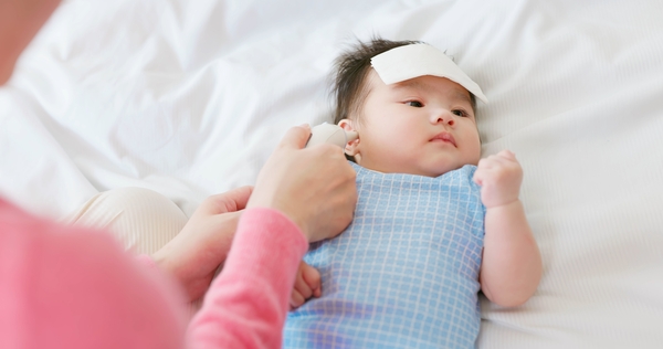 Mẹ đang đo nhiệt độ cho bé với nhiệt kế điện tử